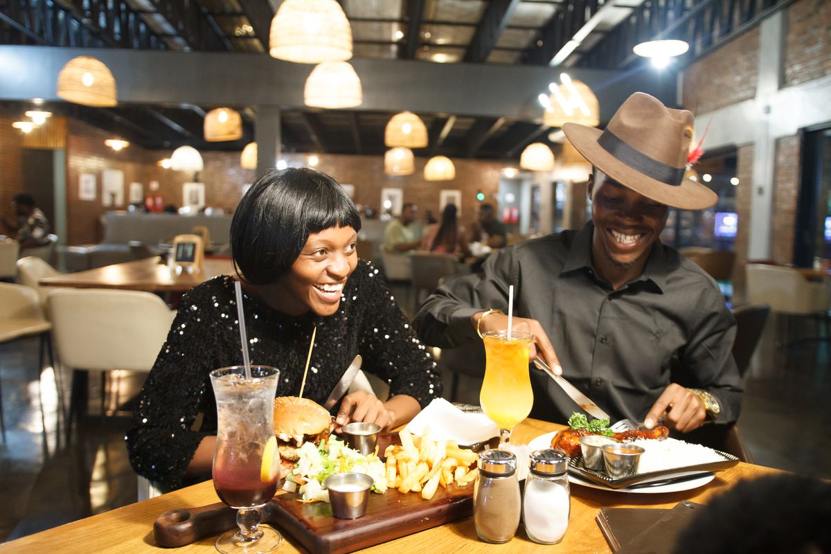 Un couple partage un repas dans un restaurant chaleureux