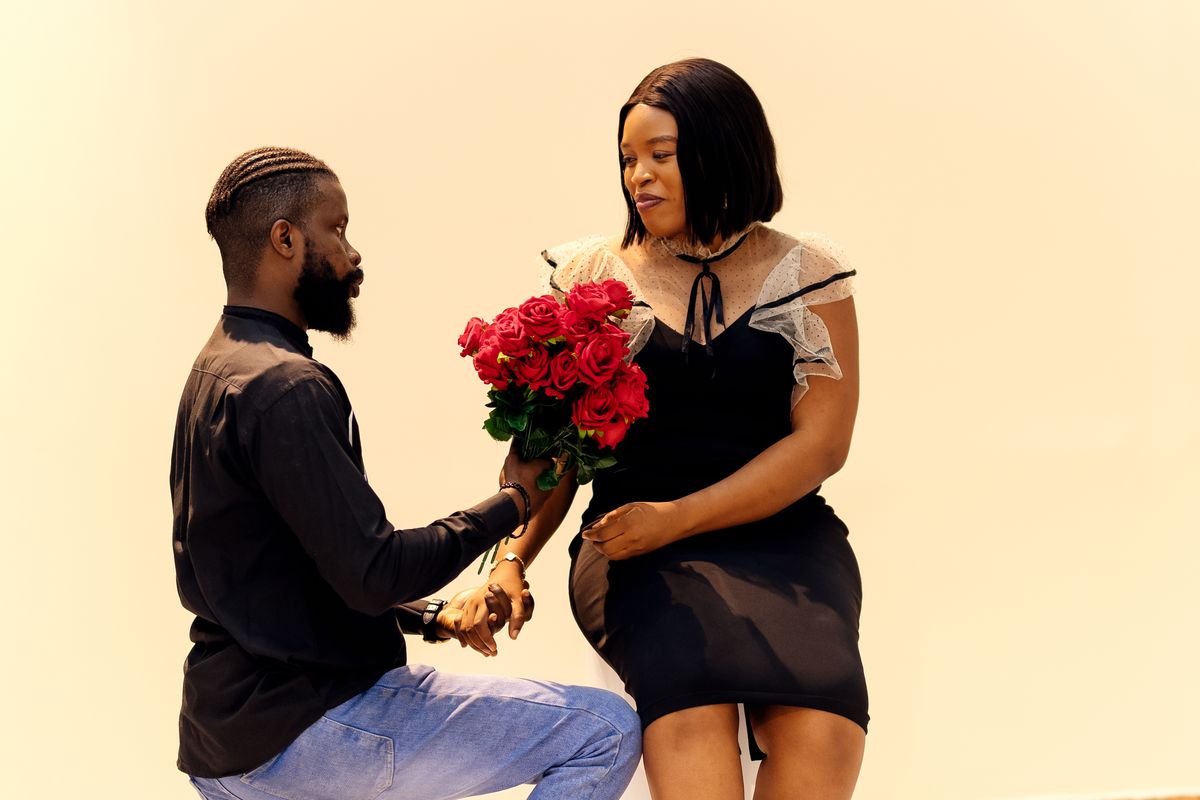 Un homme offre un bouquet de roses rouges à une femme