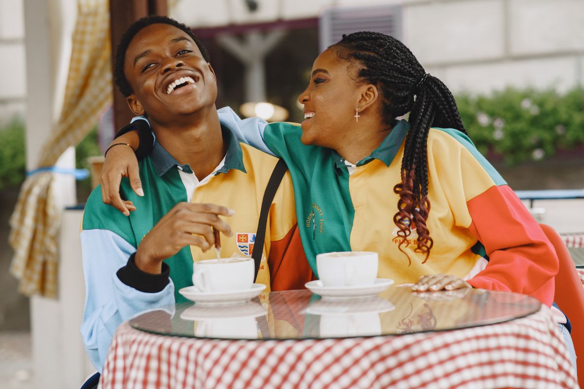 Un couple rit ensemble à la table d’un café