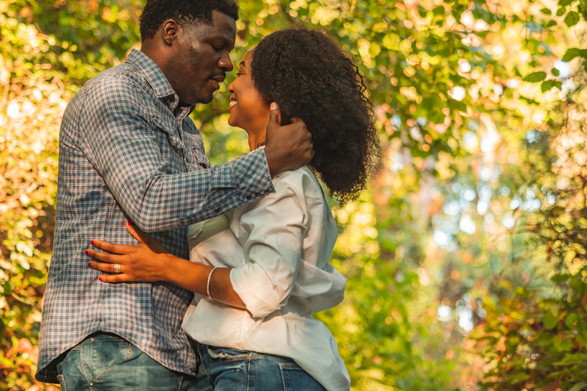 Un couple s’enlace dans un parc en automne